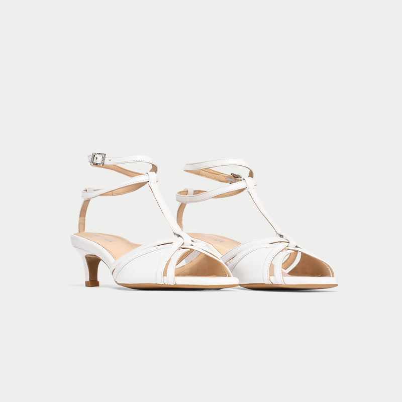 White strappy sandals on a light gray background