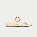 Beige sandal with a metallic buckle on a light gray background