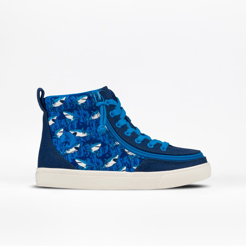 The SALE - Blue Sharks BILLY Classic Lace High by BILLY Footwear is a blue kids’ high top sneaker with a white sole, blue laces, swimming sharks on the side panel, and a wraparound zipper for easy on and off.