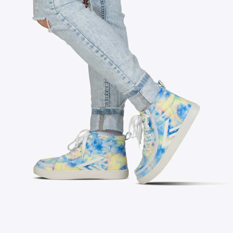 A person in light blue ripped jeans and SALE - Blue Watercolor BILLY CS High sneakers by BILLY Footwear, featuring white laces and soles, stands against a plain white background.