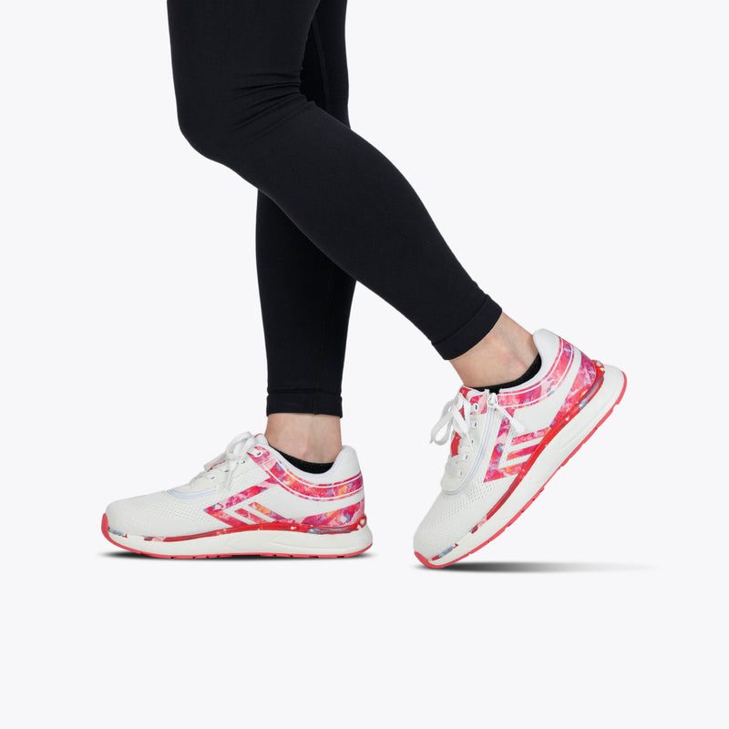 A person wearing black leggings and SALE - Pink Marble BILLY Sport Inclusion shoes by BILLY Footwear, featuring pink and red patterns, walks or poses against a plain white background.