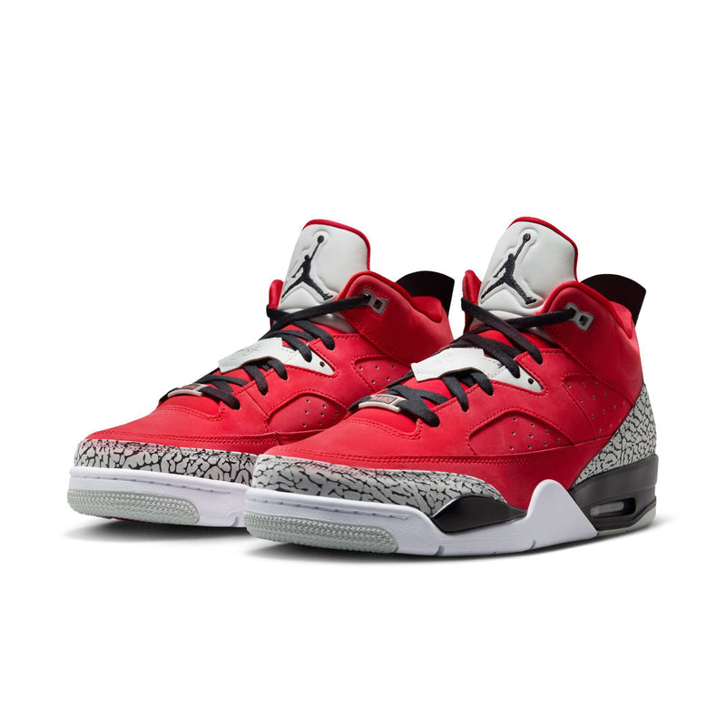 Red low-top sneakers with black laces, grey speckled sides, and white outsole
