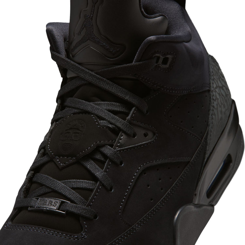 Close-up of black sneaker side: laces, stitched overlays, and air window midsole