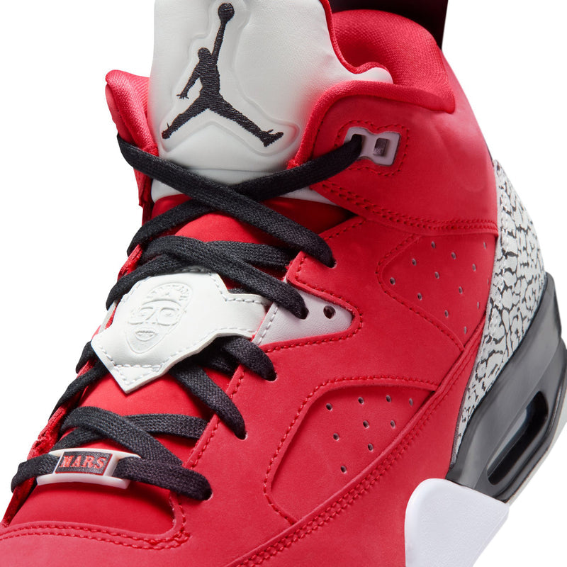 Close-up of red sneakers with black laces, white tongue with Jordan logo, and eyelets