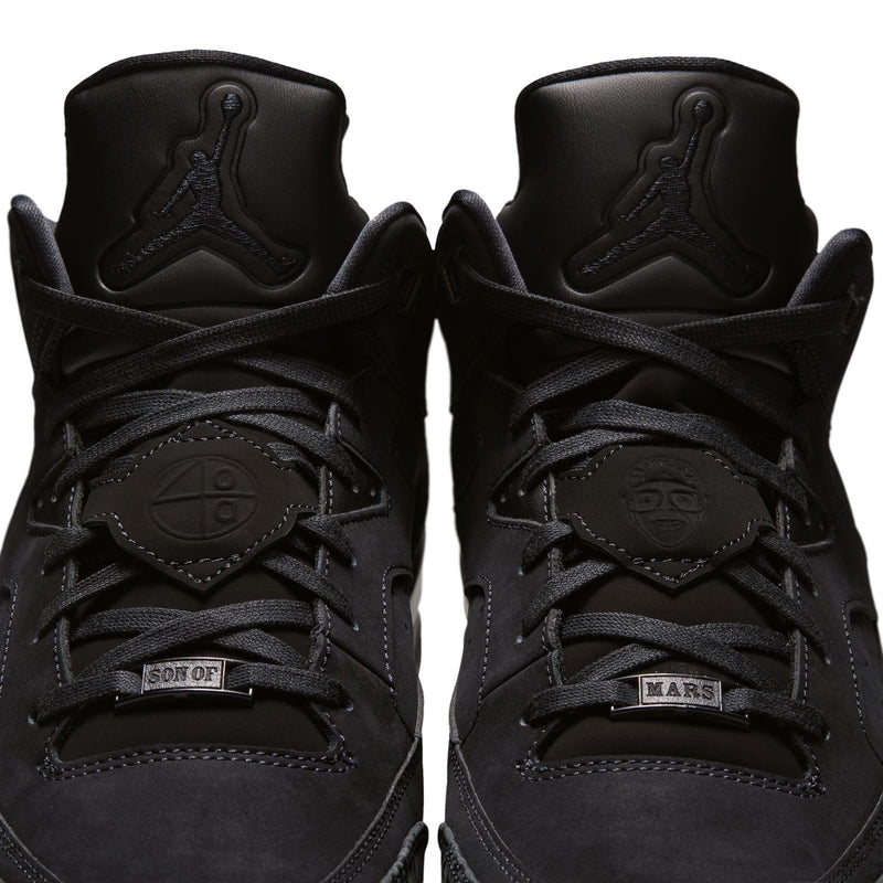 Pair of black low-top sneakers, top view of lace-up and tongue with logo emblems