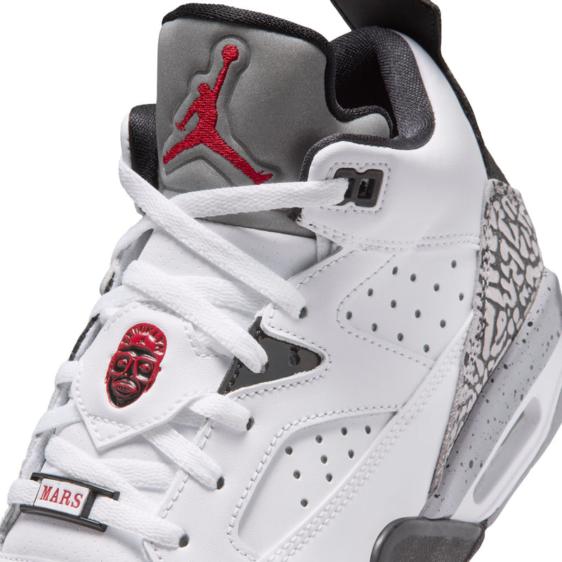 Youth sneakers close-up: white laces, red Jumpman on tongue, cement-gray speckled collar