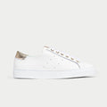 White sneaker with gold accents on a light gray background