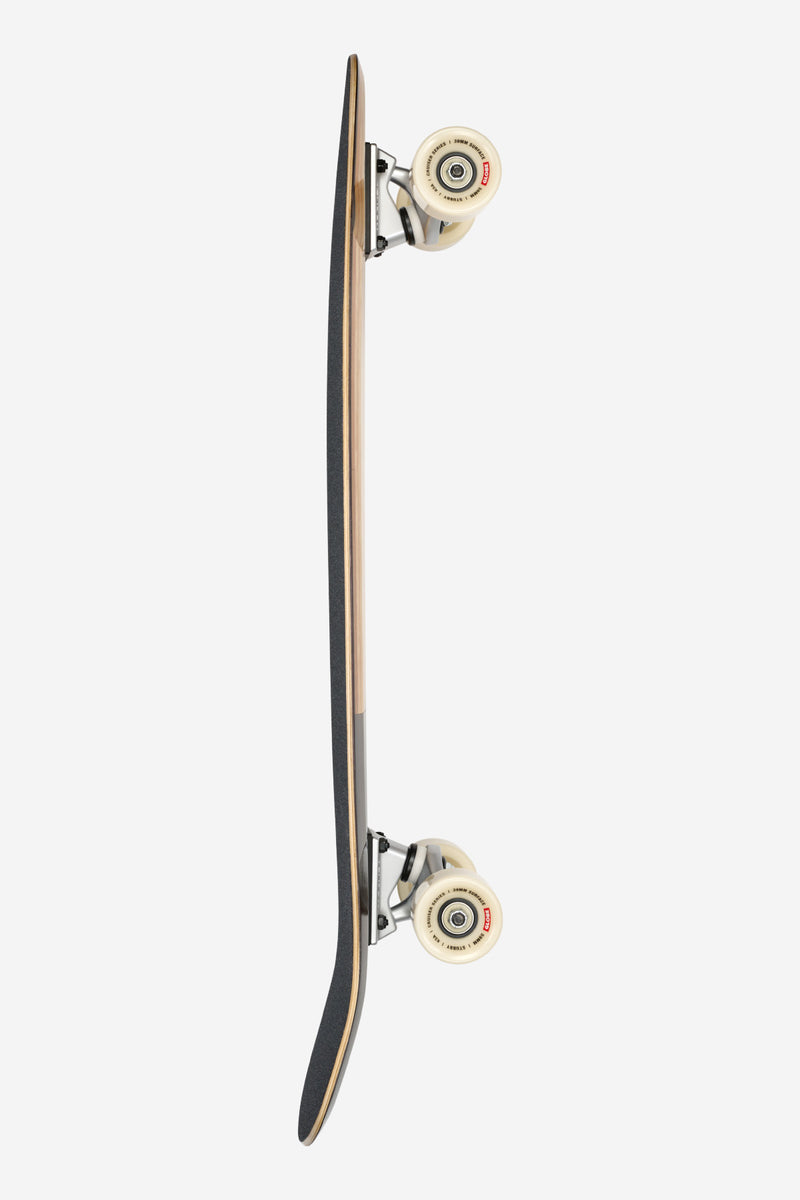 Side profile of Stubby Cruiserboard Inner Savage with cream trucks and beige wheels mounted to a two tone deck