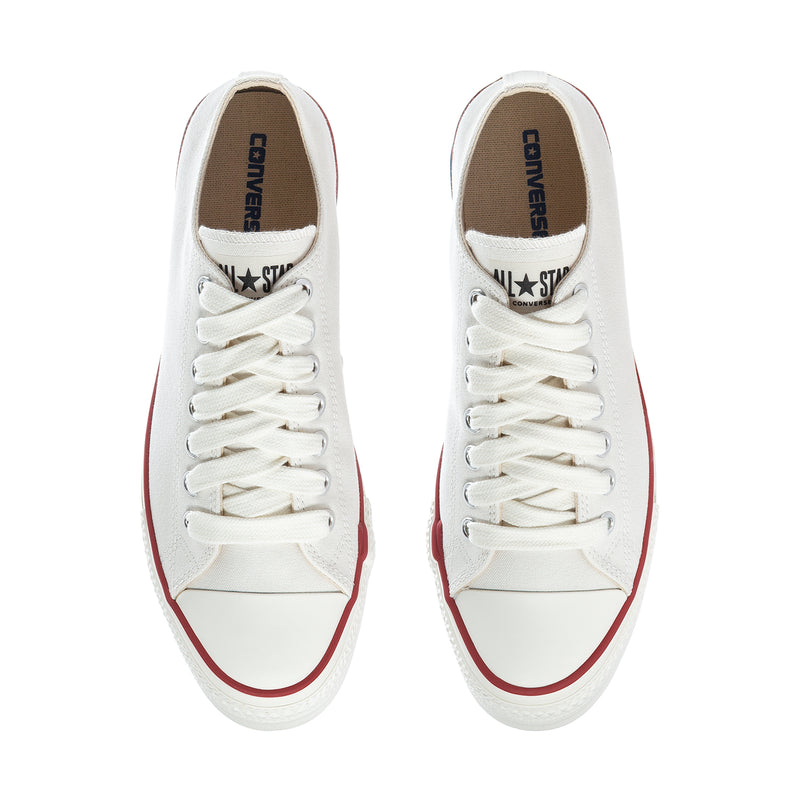 Pair of men's low-top sneakers, white canvas/leather look, lace-up front, Converse logo.