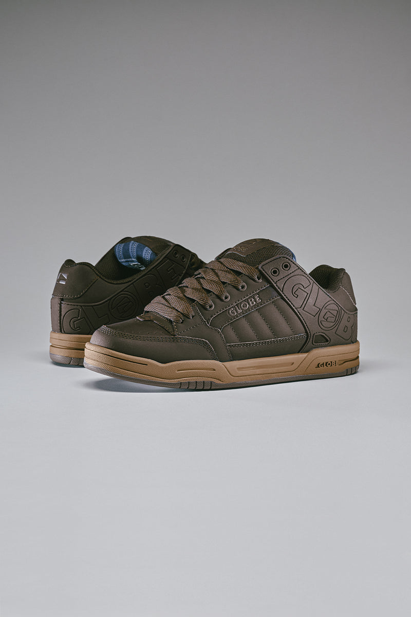 Brown Tilt sneakers with cowprint panels and embossed Globe logo along the side and a white midsole.