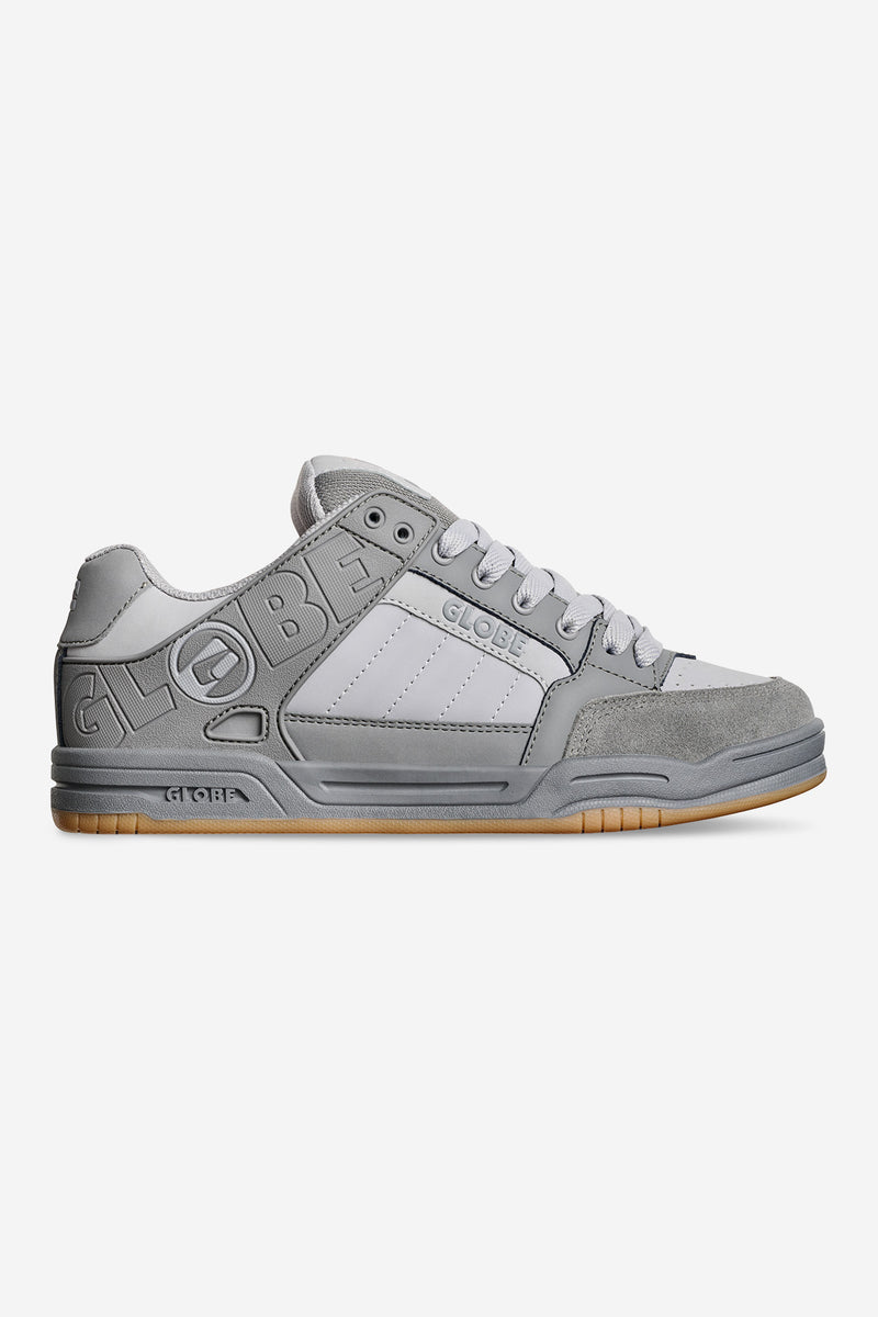 Side profile of Globe Tilt Smoke sneaker in grey with embossed branding and gum sole