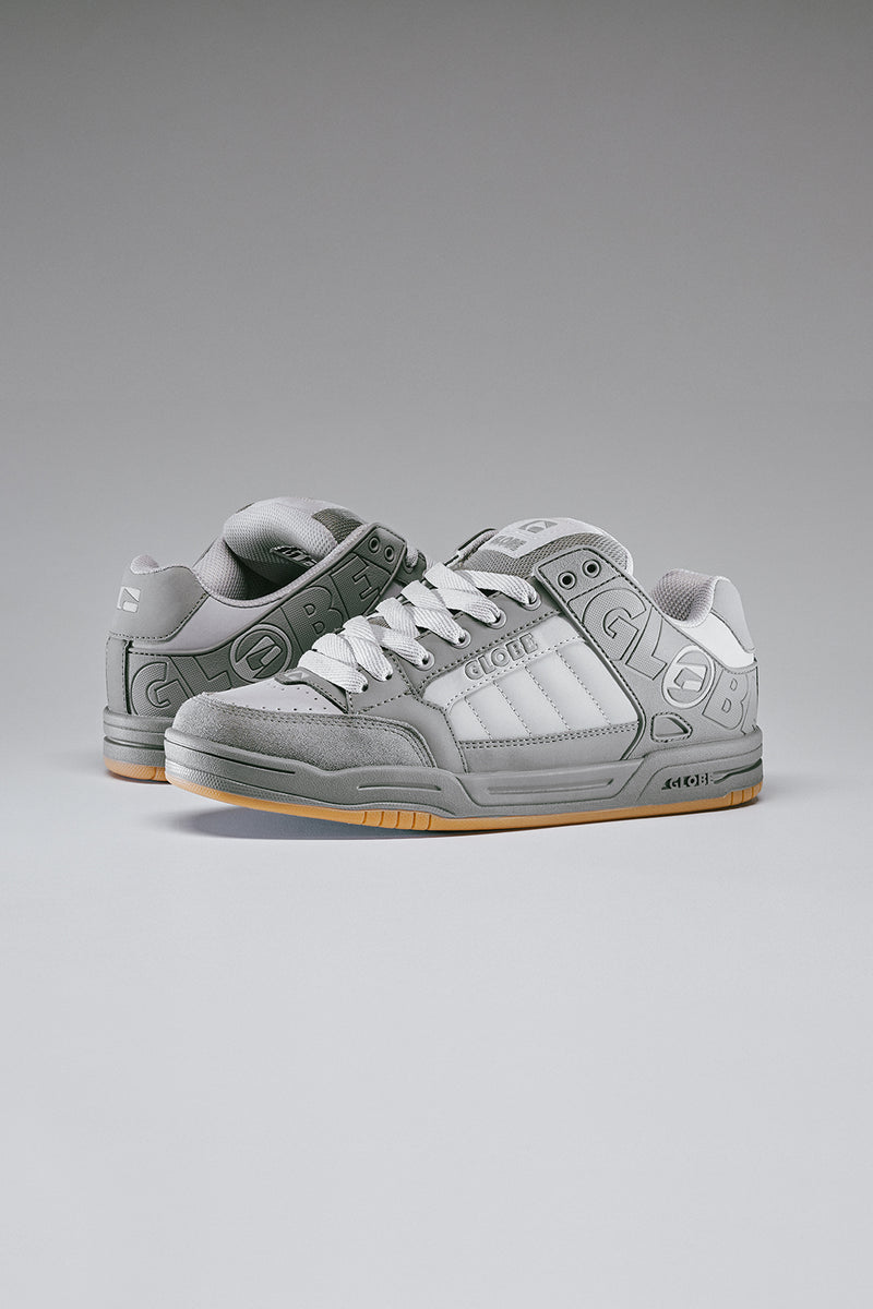 Pair of Globe Tilt Smoke skate shoes in grey tones shown from a three quarter angle with white laces.