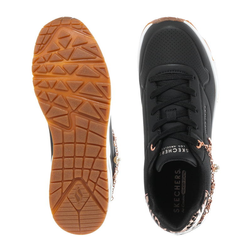 Black sneaker outsole tread with brown rubber base and lace-up upper