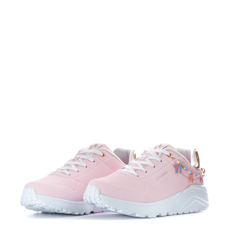 Pair of pink youth sneakers with gold heel trims, white laces, and multicolor charms