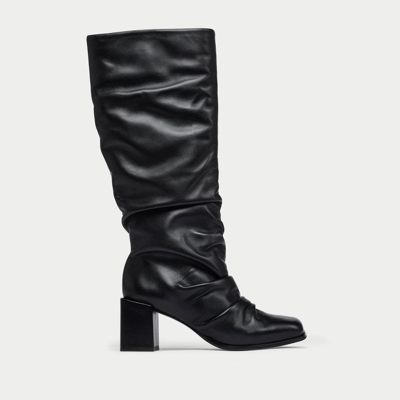 Black knee-high boot on a light gray background