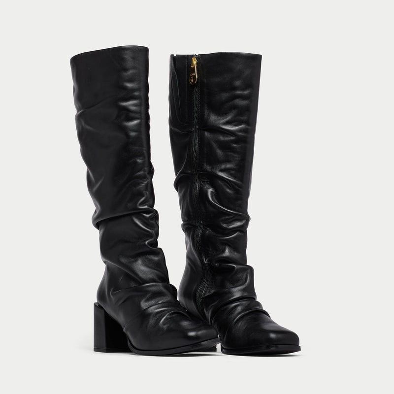 Pair of black knee-high boots on a light gray background