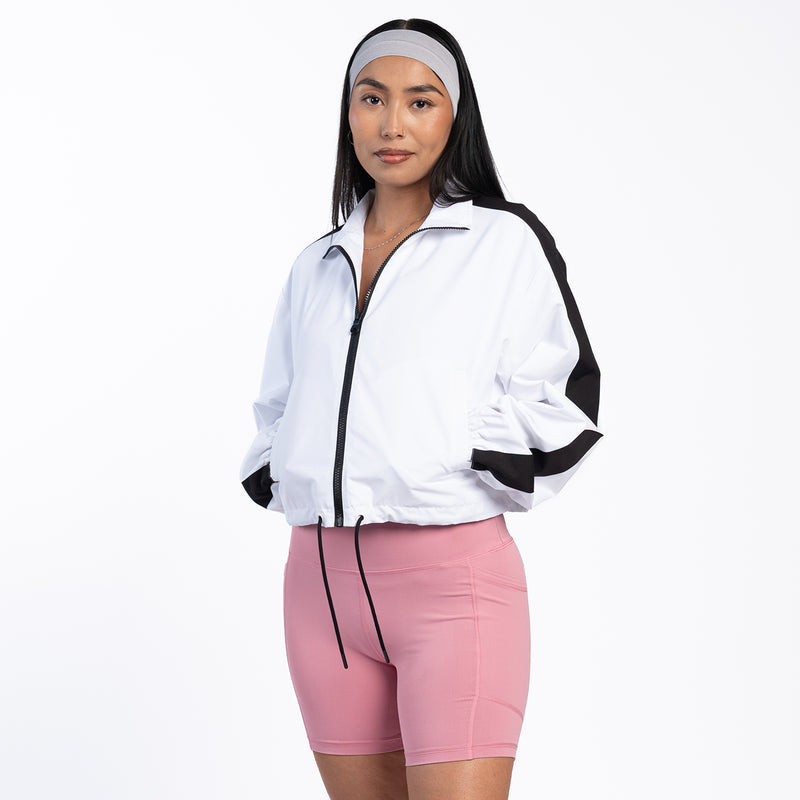 Women's white windbreaker jacket with black trim, full zip, and side pockets