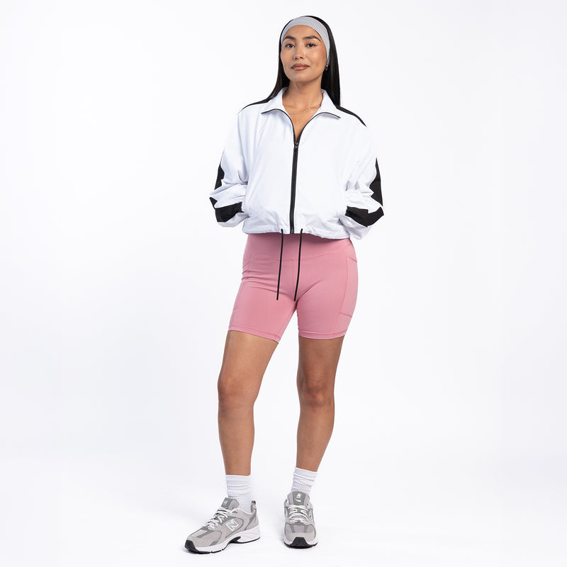 Women's white windbreaker jacket with black zipper and sleeve panels, elastic cuffs