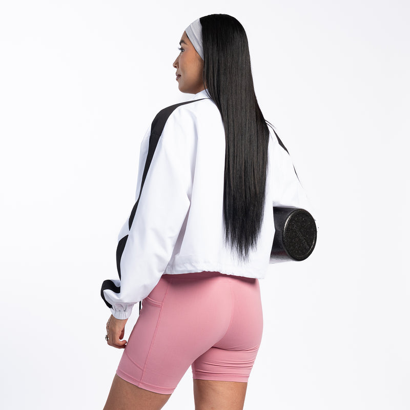 Women's white windbreaker jacket with black shoulder panels and elastic cuffs