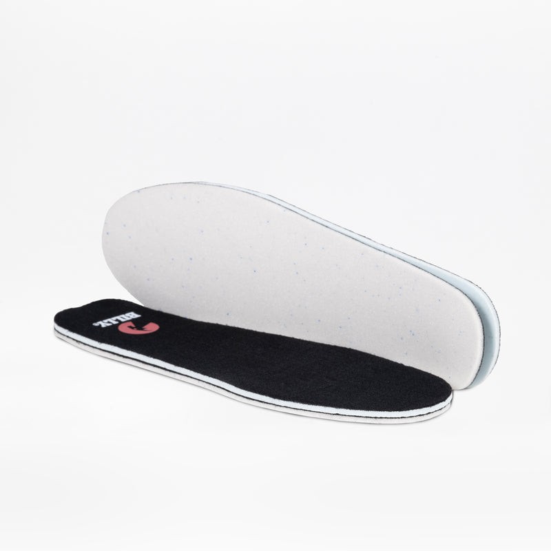 A pair of black and white insoles for the Women's Black BILLY Cozy II by BILLY Footwear—one flat with the black side up, one upright showing the white underside—are displayed on a plain white background.