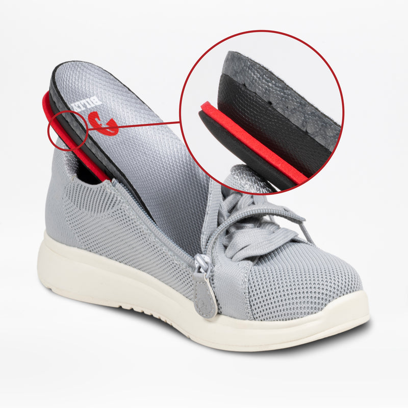 A women's grey BILLY Comfort Knit sneaker from BILLY Footwear with its insole lifted, revealing a circular inset close-up of the breathable, layered insole material.