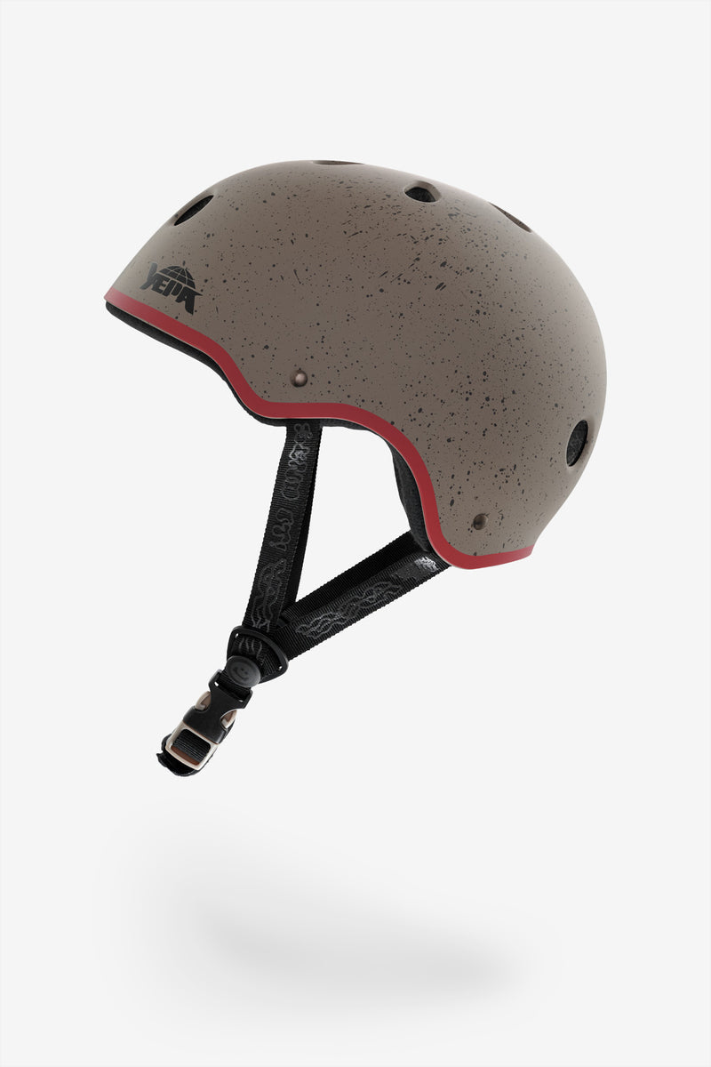 Rear-left view of YEPA T-Shell Plus helmet in stone speckle with red edge and visible chin strap.