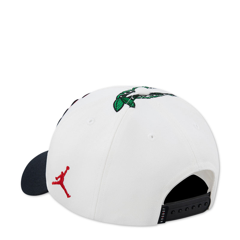Youth Jordan dad cap, white with black brim, green bow detail and red Jumpman logo
