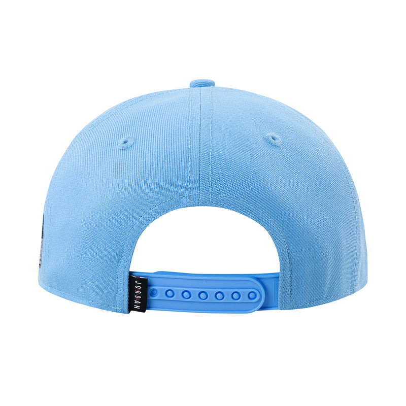 Youth blue snapback cap inside view with adjustable strap and stitched eyelets